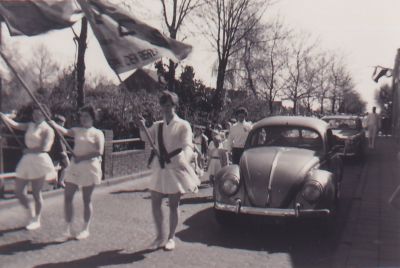 Koninginnedag
D E S Meisjes zwaaien met de clubvlag ( D E S Algemeen) .
Rechts op het trottoir gymleraar Heineman  van DIO RK.
Kaarsrechts. Staccato stem met Indonesisch accent.
Vertelde altijd verhalen over zijn kamptijd in Indonesie. 1/2 uur gym en 3/4 uur verhalen.
Ging eens in de week biljarten met mijnheer de voorzitter Galesloot.

