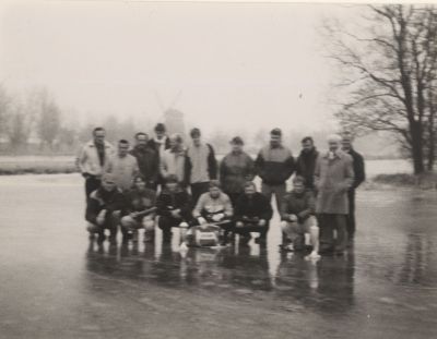Bestuur-en-vrijwilligers-Ijsclub
Groepje mensen op ijsbaan. Achtergrond: Molen Ankeveensepad.
