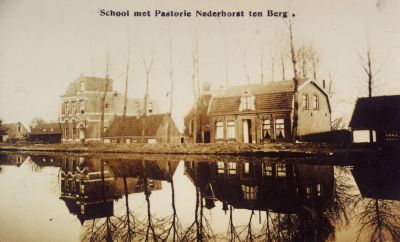 School-met-Pastorie
Gezicht op de Gereformeerde Kerk en school .
De zwarte schuur  uiterst links  was van de heer Pos en was de eerste repetitie-ruimte van Crescendo .
Van de gebouwen staat de rechter  grote  woning er thans  2006  nog en wordt bewoond door
de fam P Gouw  daarvoor door de fam Griffioen
