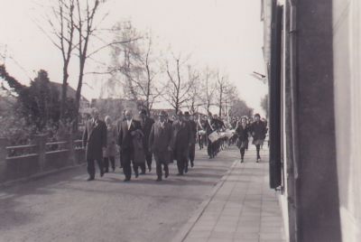 Oranjevereniging
Oranjebestuur gaat de drumband van Crescendo voor op de Voorstraat.
De muur is de afscheiding van de tuinen aan het water van van Groeningen en oude Gerrit Lodeweegs.
Voor links Jan Snel jr, Midden Theunis Bouwer, Rechts Jan Westhoff.
2e rij Links Gerrit Kostelijk en Willem Mulders.
Gerrit Lodeweegs   de timmerman
Trefwoorden: Koninginnedag