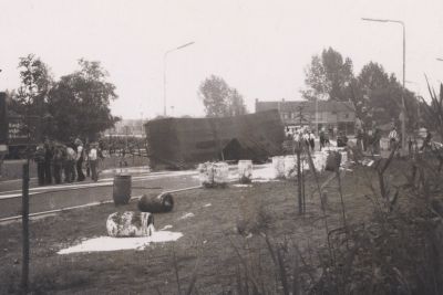 1e-ongeval-bocht-Overmeerseweg-Randweg
Op 24 juni 1977 gebeurde het eerste ongeval in de nieuw aangelegde bocht 
Overmeerseweg-Randweg, tegenover de schoenmakerij van G.Kroon.
Een aanhanger, geladen met vaten  met een soort latex voor gebruik bij de fabricatie van lijm,
slaat om en verliest zijn lading, waardoor de lading over de weg stroomt.
Nadat de aanhanger weer op zijn wielen is gezet worden de leeggelopen vaten weer zoveel
mogelijk gevuld met de uitgestroomde latex, waarna de weg  met gebruikmaking van de 
hogedruk-brandweerauto, met water wordt schoongespoten. 
De gemaakte foto-s zijn voorgelegd  aan en besproken in de vergadering van het
college van burgemeester en wethouders op 28 juni 1977.
De beslissing was om voor de bocht een verkeersbord -aanbevolen snelheid 30 KM- te plaatsen.
Trefwoorden: Ongeluk, Randweg, Brandweer, verkeersborden