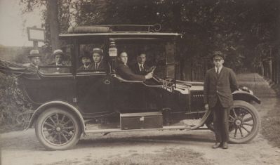 Oprijlaan-Kasteel-Nederhorst
Auto met onbekende mensen, ernaast staat de chauffeur gezien de pet die hij draagt.
