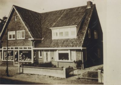 Winkel huishoudelijke artikelen
Winkelpand-woonhuis van de fam Scherpenhuijsen.
Deze winkel verkocht alles van: huishoudelijke artikelen, spijkers, schroeven, kachels, schaatsen enz. 
Enige tijd apotheek geweest en later verbouwd tot woonhuis
