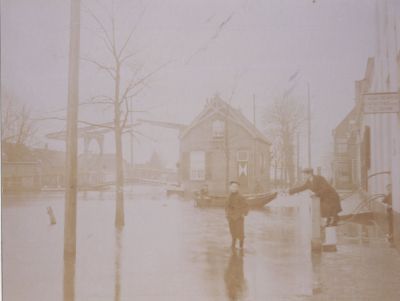 Overstroming-van-de-Reevaart
Vóór de afsluiting van de afsluitdijk steek het water in de Reevaart zo hoog dat de Voorstraat en de Brugstraat volledig blank kwamen te staan.
Op het uithangbord staat: Tabak-sigaren,Thee-koffie, P.J. Van Schaik
Trefwoorden: Brug, brugwachterswoning