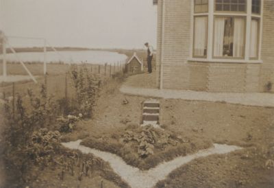 Dammerweg-huis-Fam-Versloot
Kort na de bouw van het eerste gedeelte van een rijtje huizen. 
Links naast het huis staat de heer A. Versloot.
Links van het huis het voetbalveld van de V.V. Wilskracht.
Dit was een protestantse voetbalclub die al snel opging in de v.v.Avance.
Daarachter gezicht op de Spiegelpolder.

