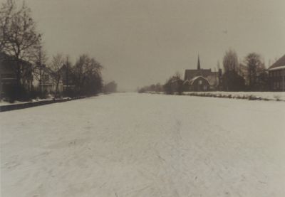 Reevaart-met-Ger-Kerk
Reevaart met ijs zonder rijp aan de bomen.
Gereformeerde kerk met torenspits.
