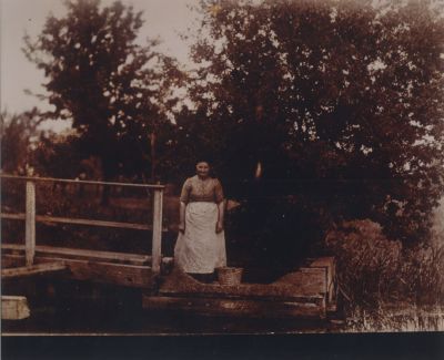 Wasvrouw-aan-de-spoelstoep
De wasvrouw aan de spoelstoep. 
Het goed werd in het begin van het ontstaan van de wasserijbedrijven in huis of in de waskeuken
met de hand gewassen, dan vele malen gespoeld in open water en daarna op de zg bleek