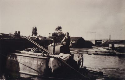 Werknemers-Ballast-Mij
Achter het stuurrad van een bak staand is David Vossepoel op weg naar de Spiegelpolder. 
Achter iedere bak was een roerstuk bevestigd. 
Om over een lege bak heen te kunnen kijken was er een verhoging geplaatst.
